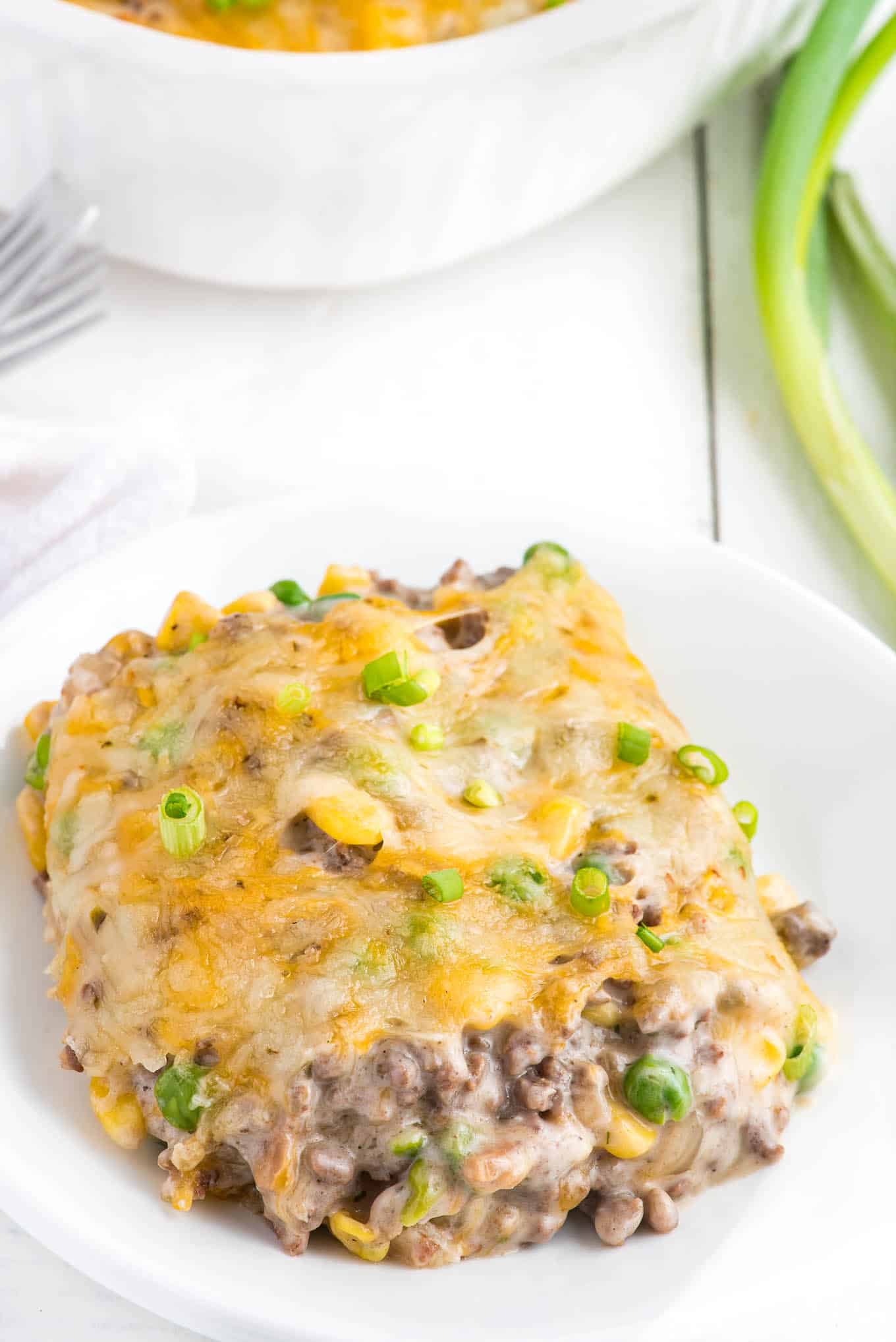 A bowl of ground beef hash brown casserole served up on a plate.