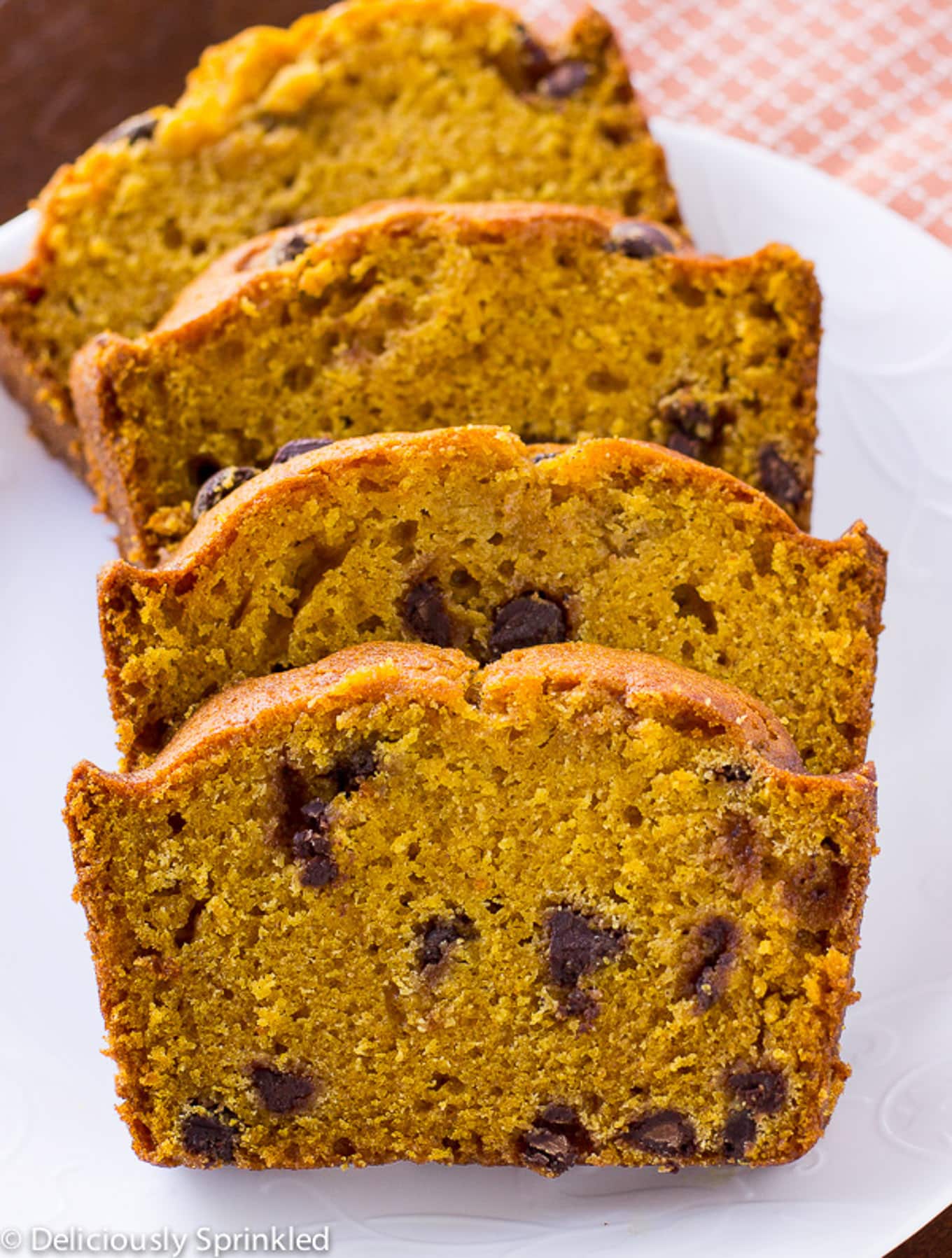 Pumpkin chocolate chip bread sliced on a white plate.