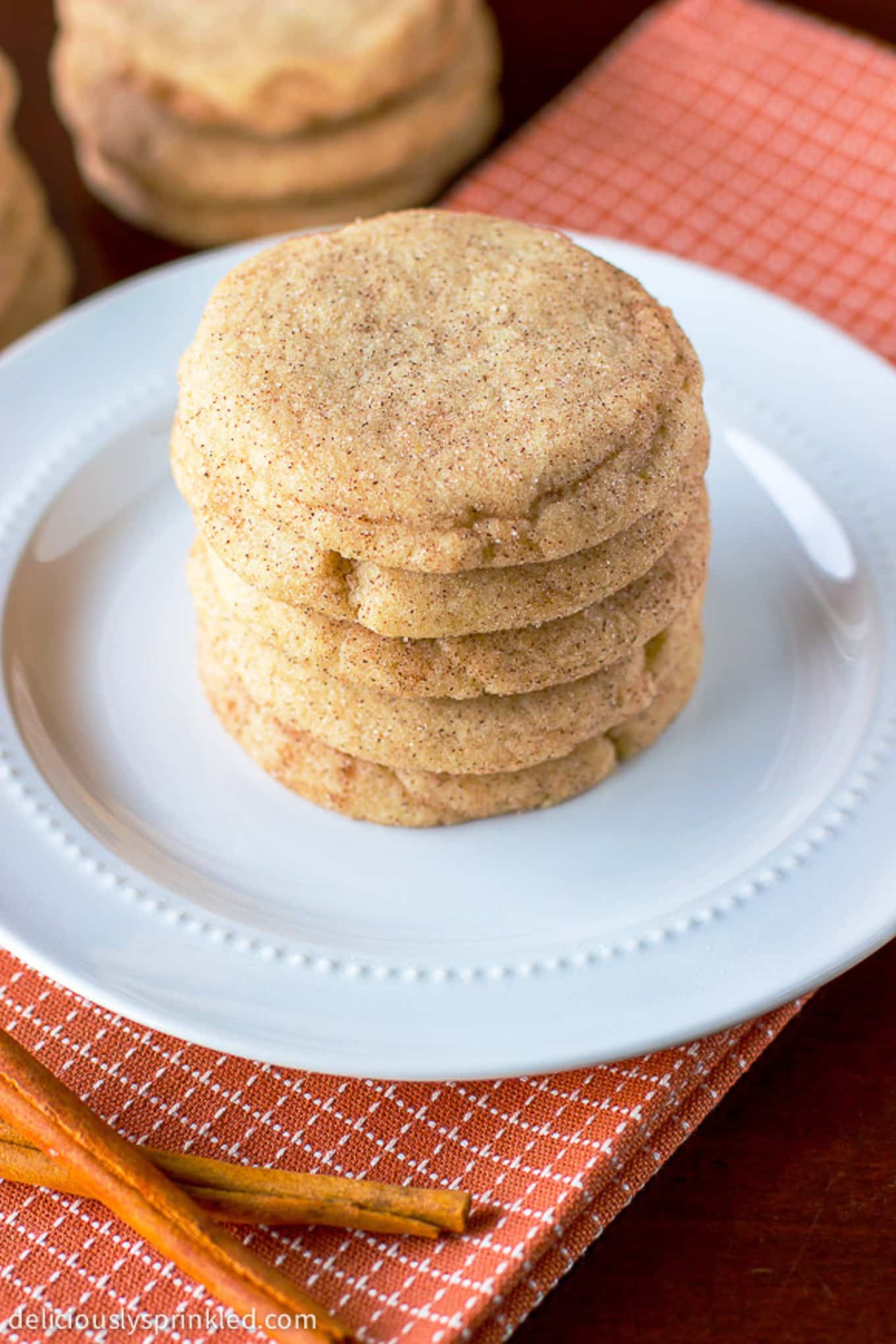Snickerdoodle cookies stacked on a white plate.