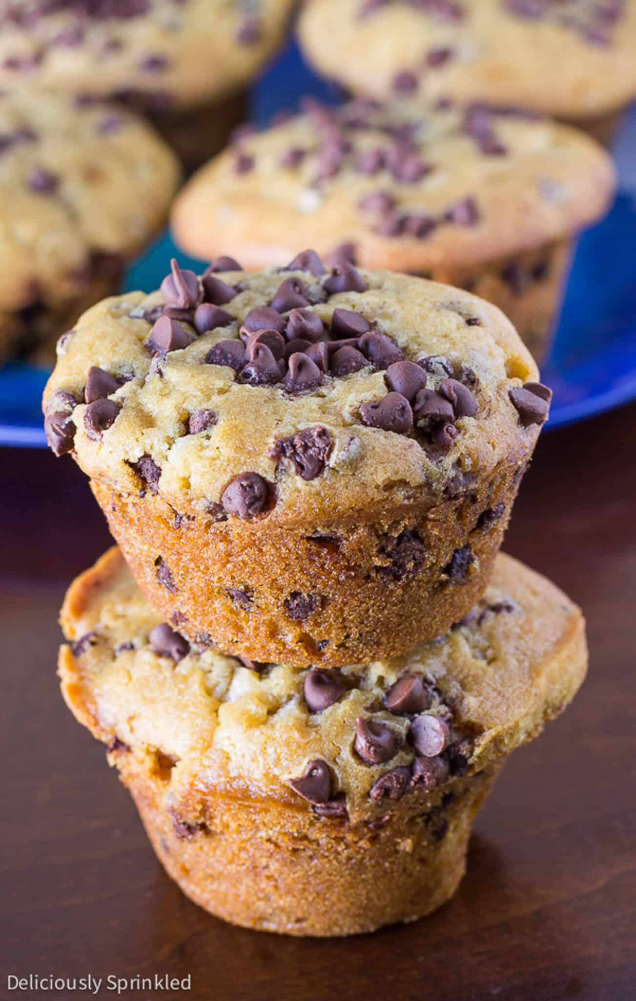 A stack of two chocolate chip muffins on the table with the platter in the background.