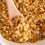 A spoonful of Stove top stuffing mix held up over the casserole dish.