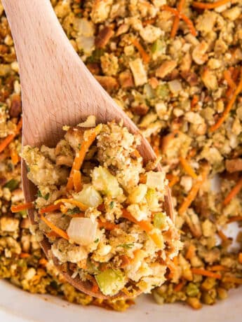 A spoonful of Stove top stuffing mix held up over the casserole dish.
