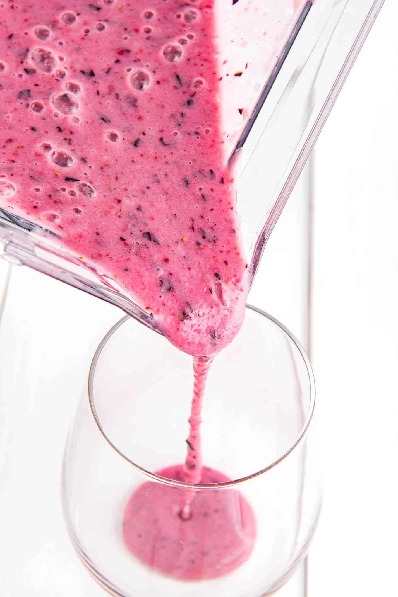 Pouring blueberry smoothie.