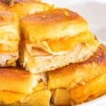Delicious turkey and cheese sliders on soft and sweet Hawaiian rolls, stacked with melted cheese, turkey, and topped with a golden-brown glaze, perfect for a quick dinner or appetizer.