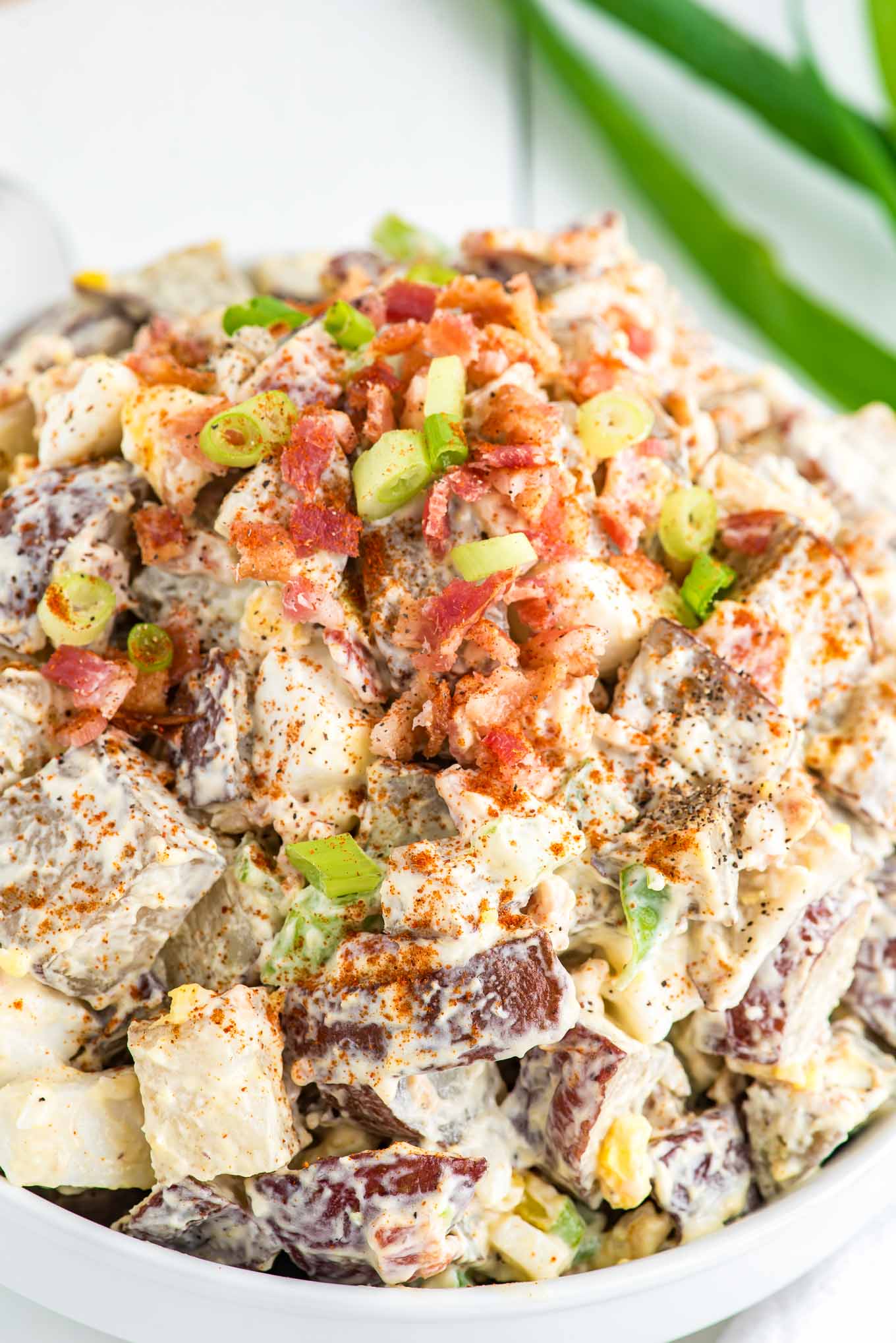 Roasted potato salad topped with chives and bacon bits. 
