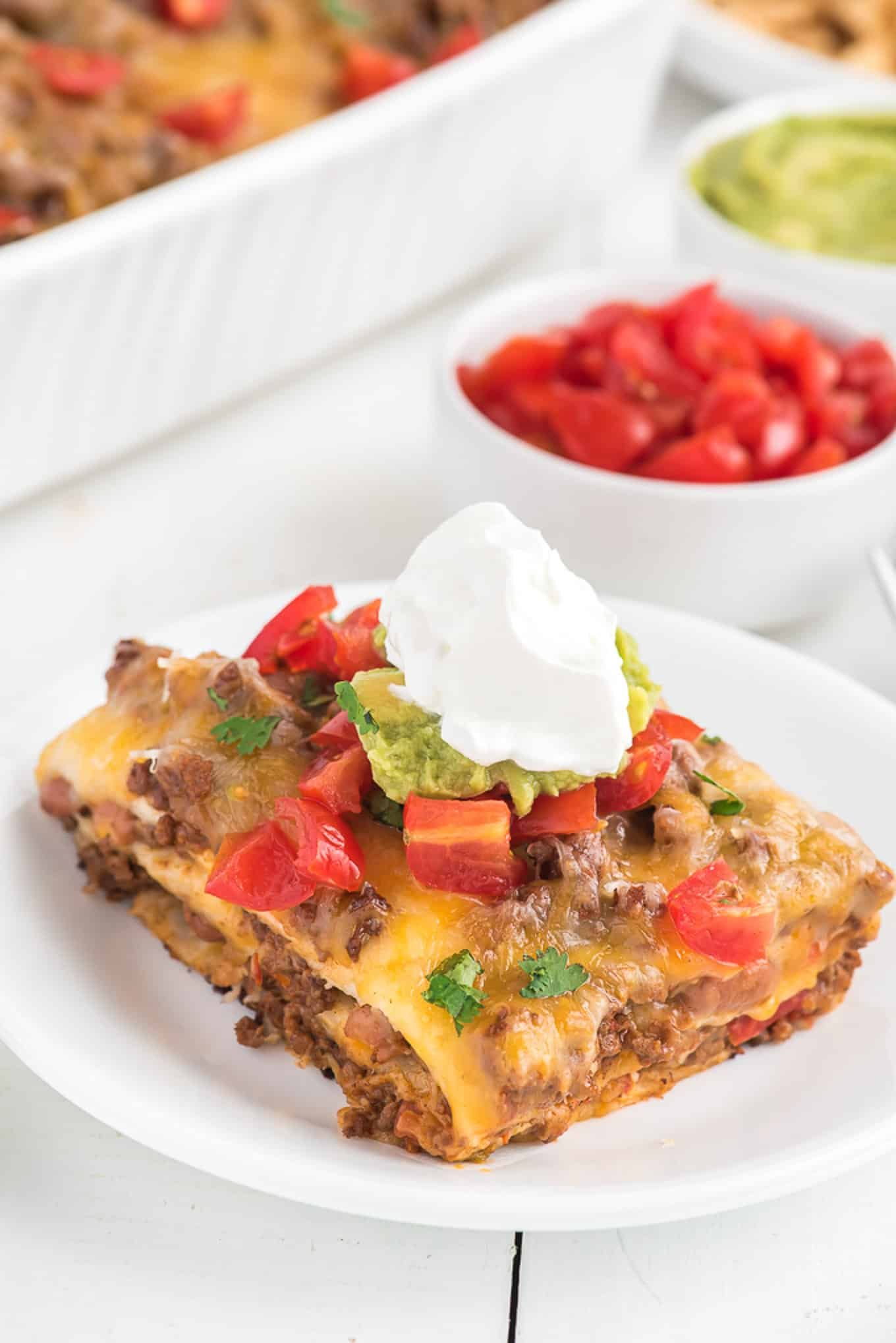 Square of taco lasagna on a plate.